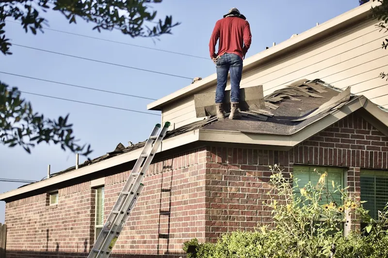 Professional roofer working on a residential roof in Walden Woods